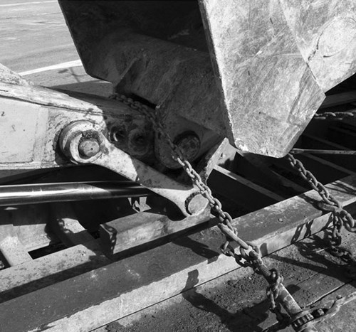 Heavy equipment chained, being transported.