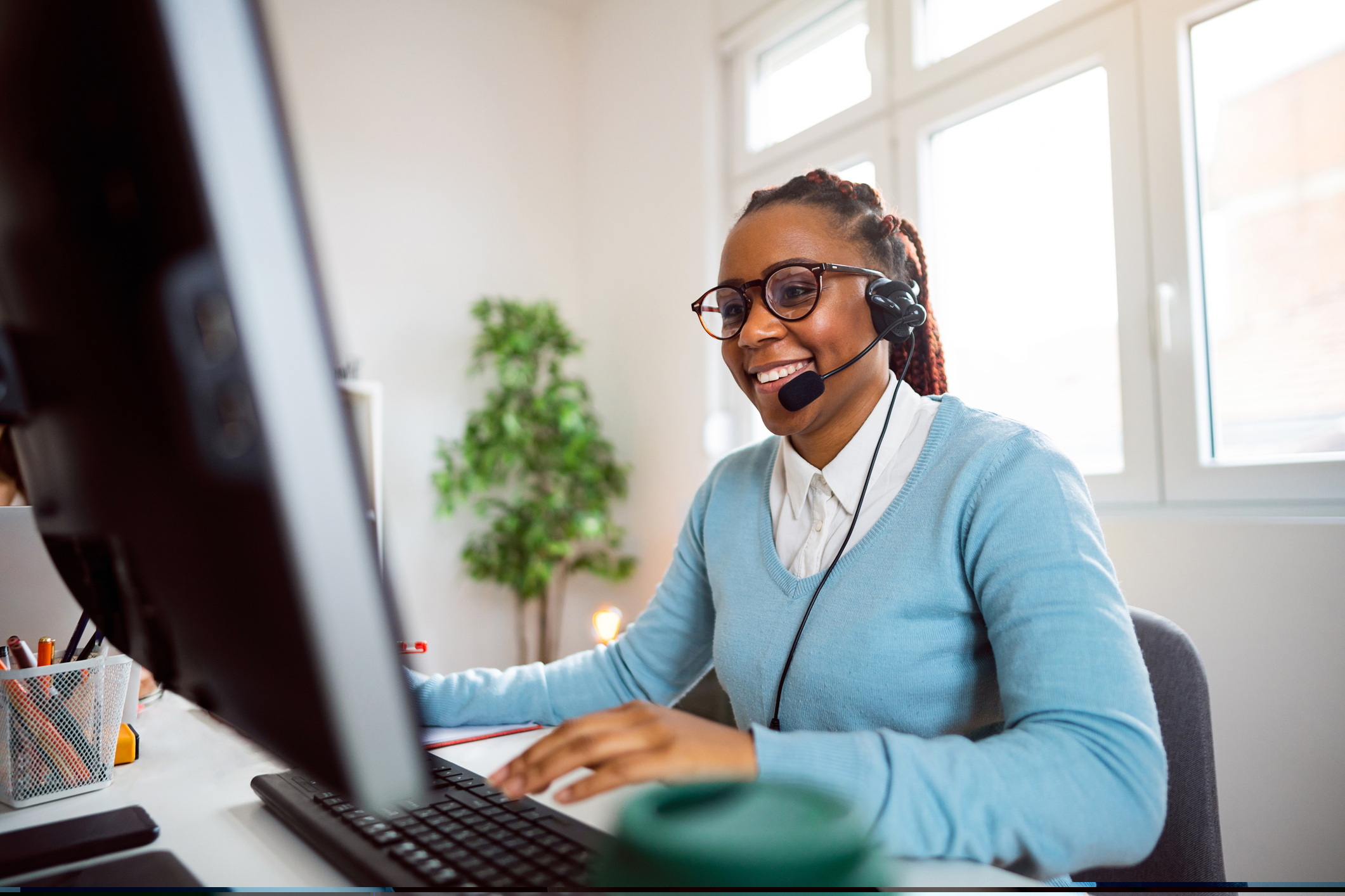 Woman on computer and talking on headset