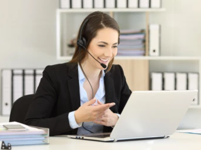 Support Clerk engaging on phone and computer.