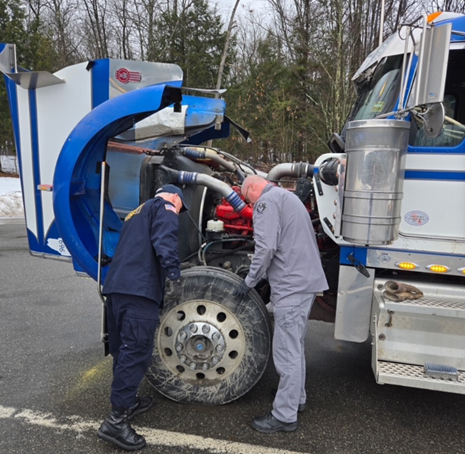 DOT Inspector looks in the engine compartment of a CMV. 