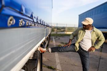 Truck driver exercising by the side of a truck