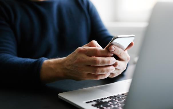 person on phone with laptop